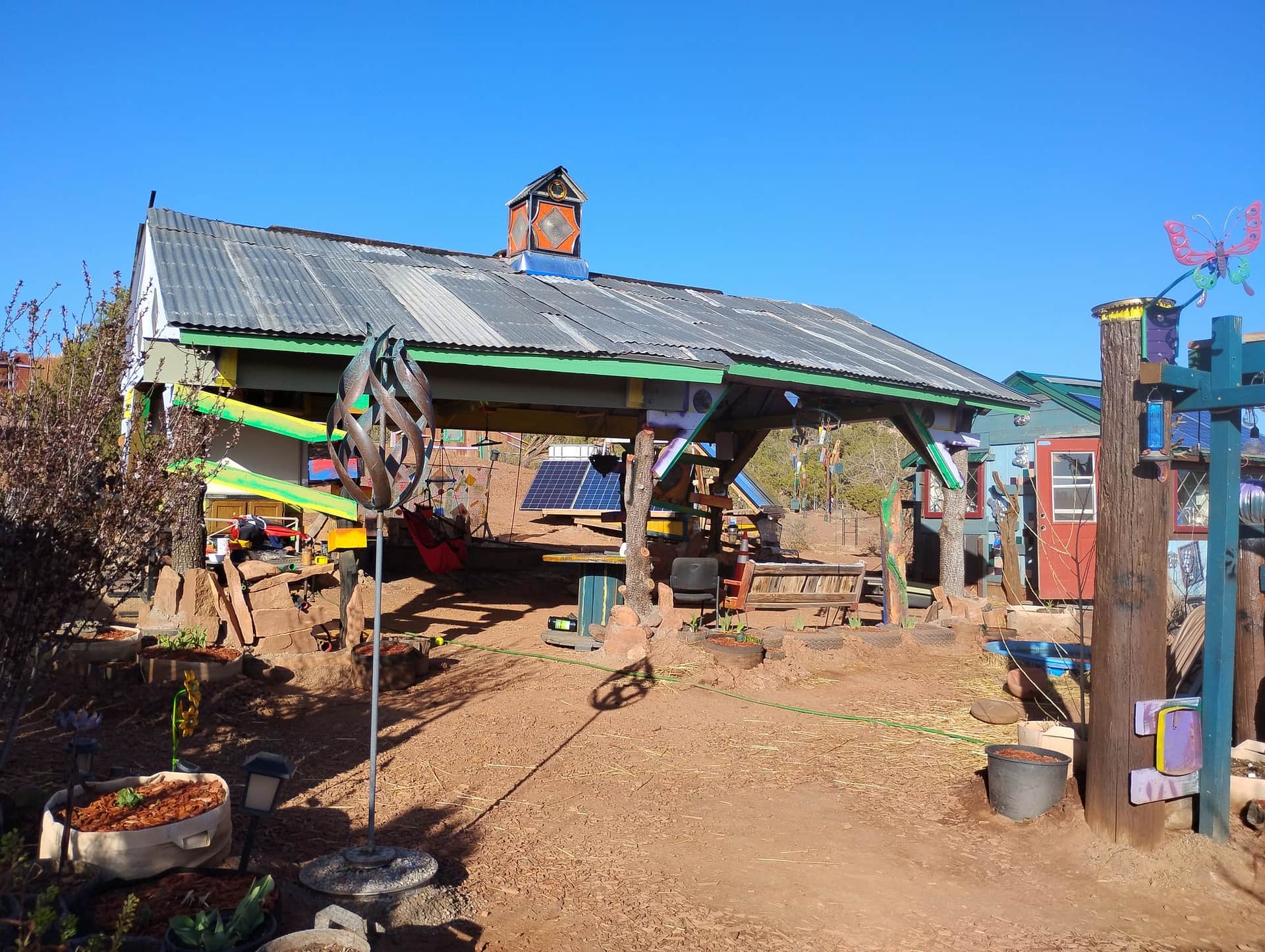 The open-air pavilion at Hope Grows with garden art and a blue sky
