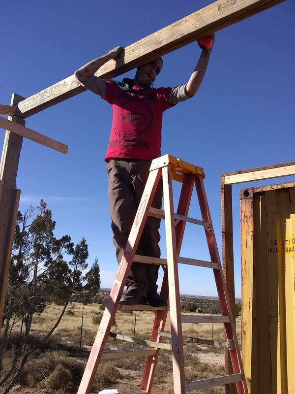 Robert Czaplicki lifting a beam into place while building at Hope Grows